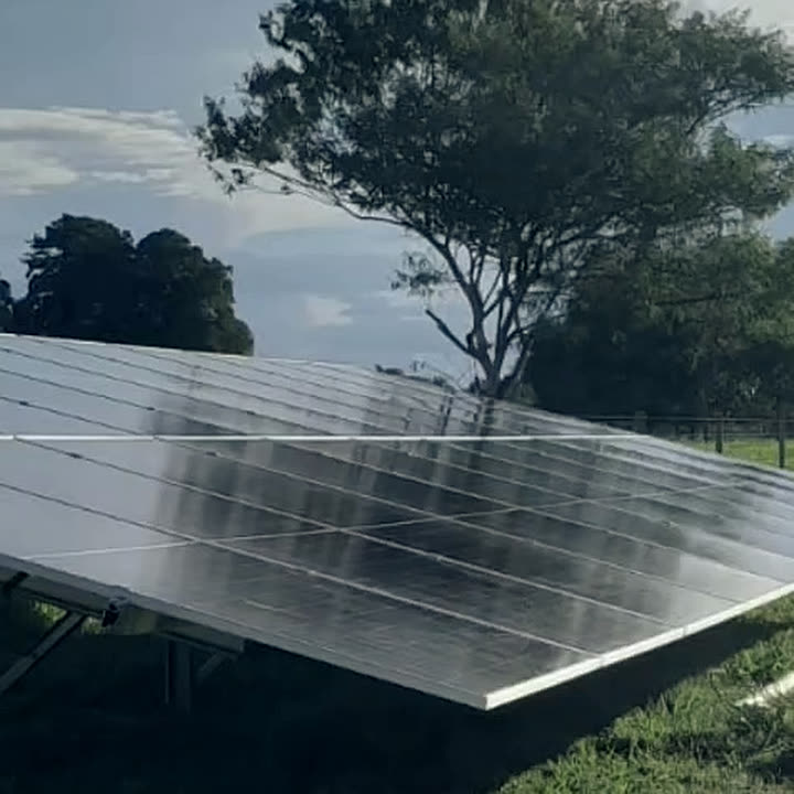 Sistema de energia solar montado em estrutura no solo, em terreno aberto.